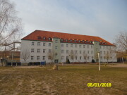 Gesamtschule Carl-Friedrich-Grabow, Haus B Aufnahme vom 05.01.2016, rotes Ziegel Spitzdach mit Dachfenster, Fassade heller Putz, 2 Treppenhäuser mit grünen Putz, auf der linken Seite Brandschutztreppe  