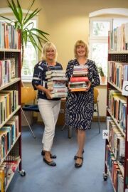 Doris Meinke und Katrin Kaesler mit Büchern in der Biblothek
