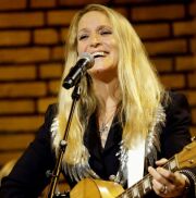 Sarah Smith mit Gitarre vor einem Mikrofon