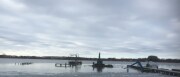 Panorama der Baustelle von links nach rechts: der See mit abgetragenen Steg, die Pfähle, der Sprungturm, die Pfahlramme und die Wasserrutsche sind zusehen